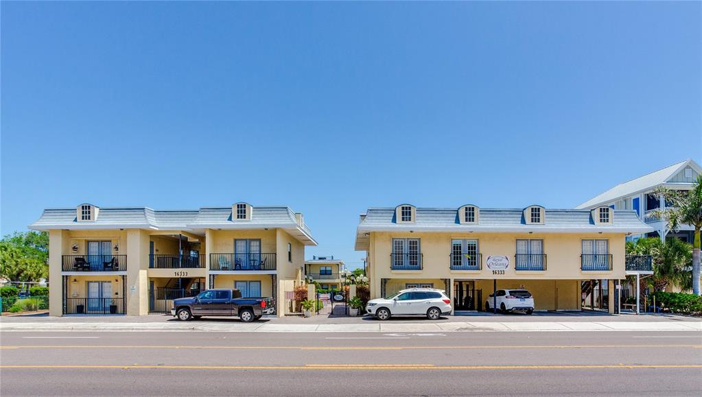 16333 Gulf Boulevard, Unit 113 Redington Beach, FL 33708 - Photo 1 of 40 a view of building with cars parked