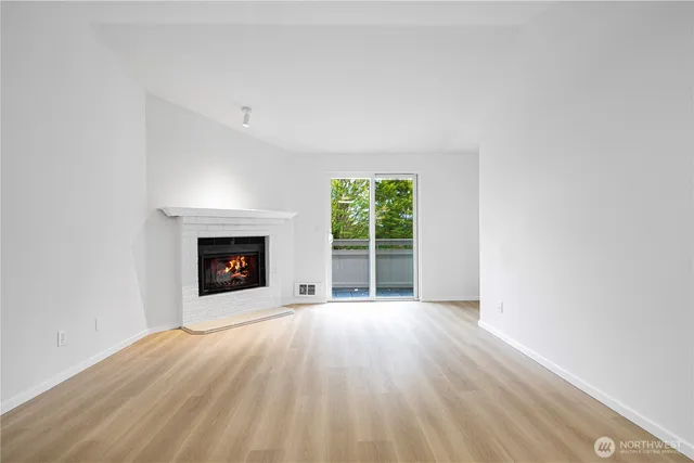 a view of an empty room with a fireplace and a window