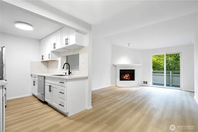 a kitchen with stainless steel appliances a white stove top oven sink and cabinets with wooden floor