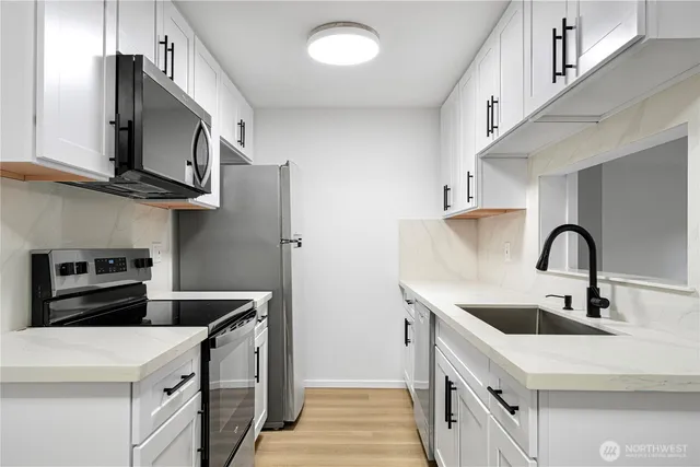 a kitchen with stainless steel appliances a sink stove and refrigerator