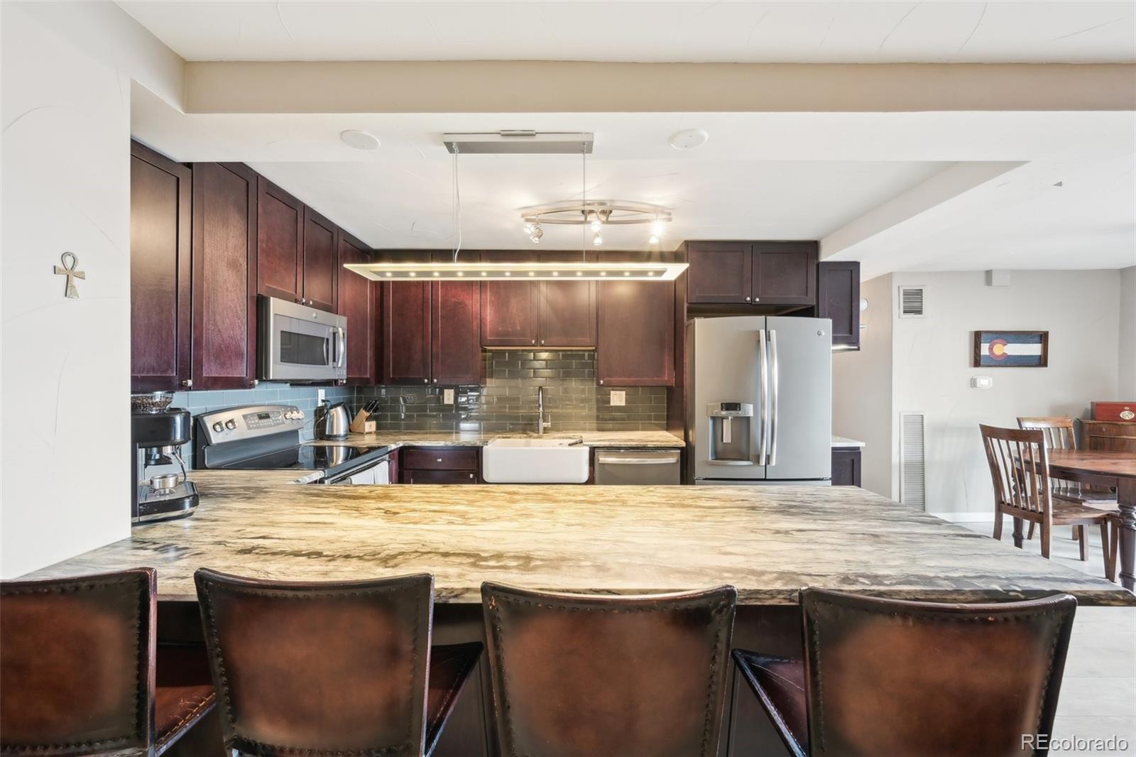2 Adams Street, Unit 705 Denver, CO 80206 - Photo 12 of 50 a kitchen with granite countertop a sink and wooden cabinets