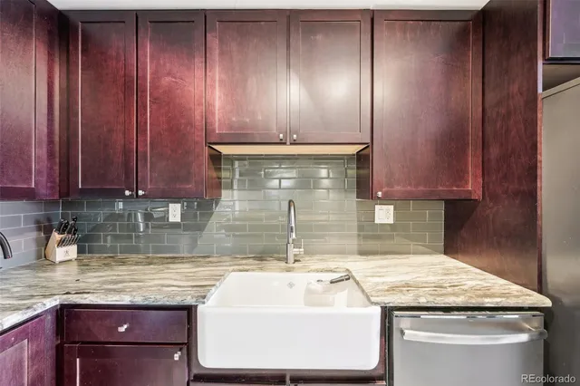 a kitchen with granite countertop wooden cabinets a sink and dishwasher