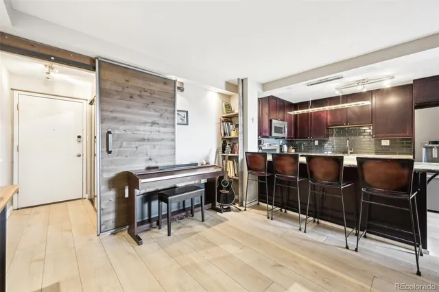 a kitchen with stainless steel appliances kitchen island granite countertop furniture and a refrigerator