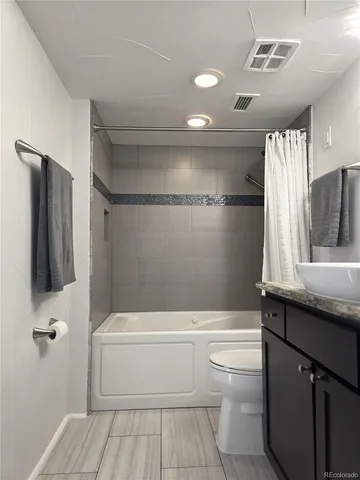 a bathroom with a granite countertop sink toilet and shower