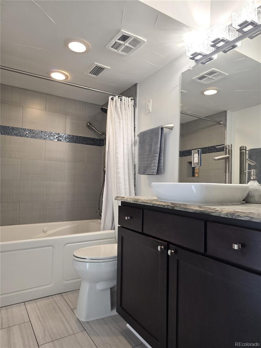 2 Adams Street, Unit 705 Denver, CO 80206 - Photo 24 of 50 a bathroom with a granite countertop sink a toilet a mirror and shower