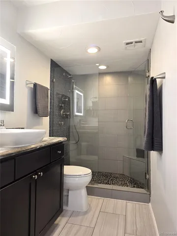 a bathroom with a sink a toilet and shower