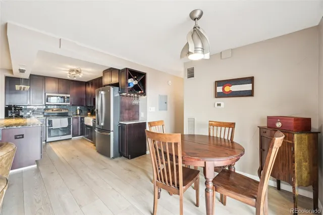 a kitchen with stainless steel appliances wooden floor dining table and chairs