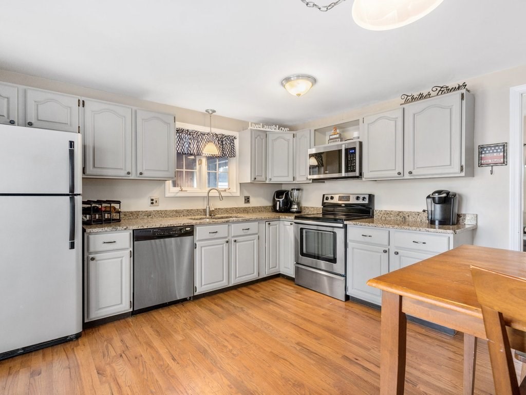 62 Middle Road Amesbury, MA 01913 - Photo 3 of 24 a kitchen with granite countertop a refrigerator stove top oven and sink