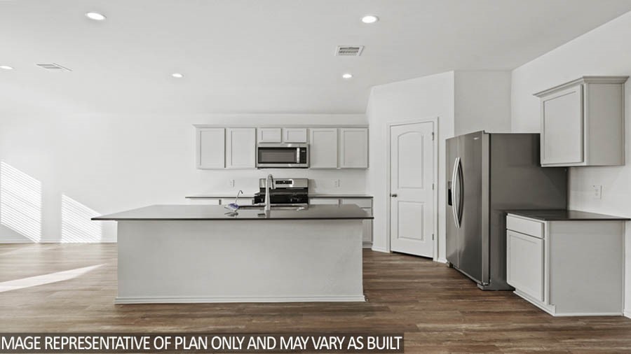 14396 Oceanblue Way Splendora, TX 77372 - Photo 3 of 24 a kitchen with stainless steel appliances a sink refrigerator and microwave