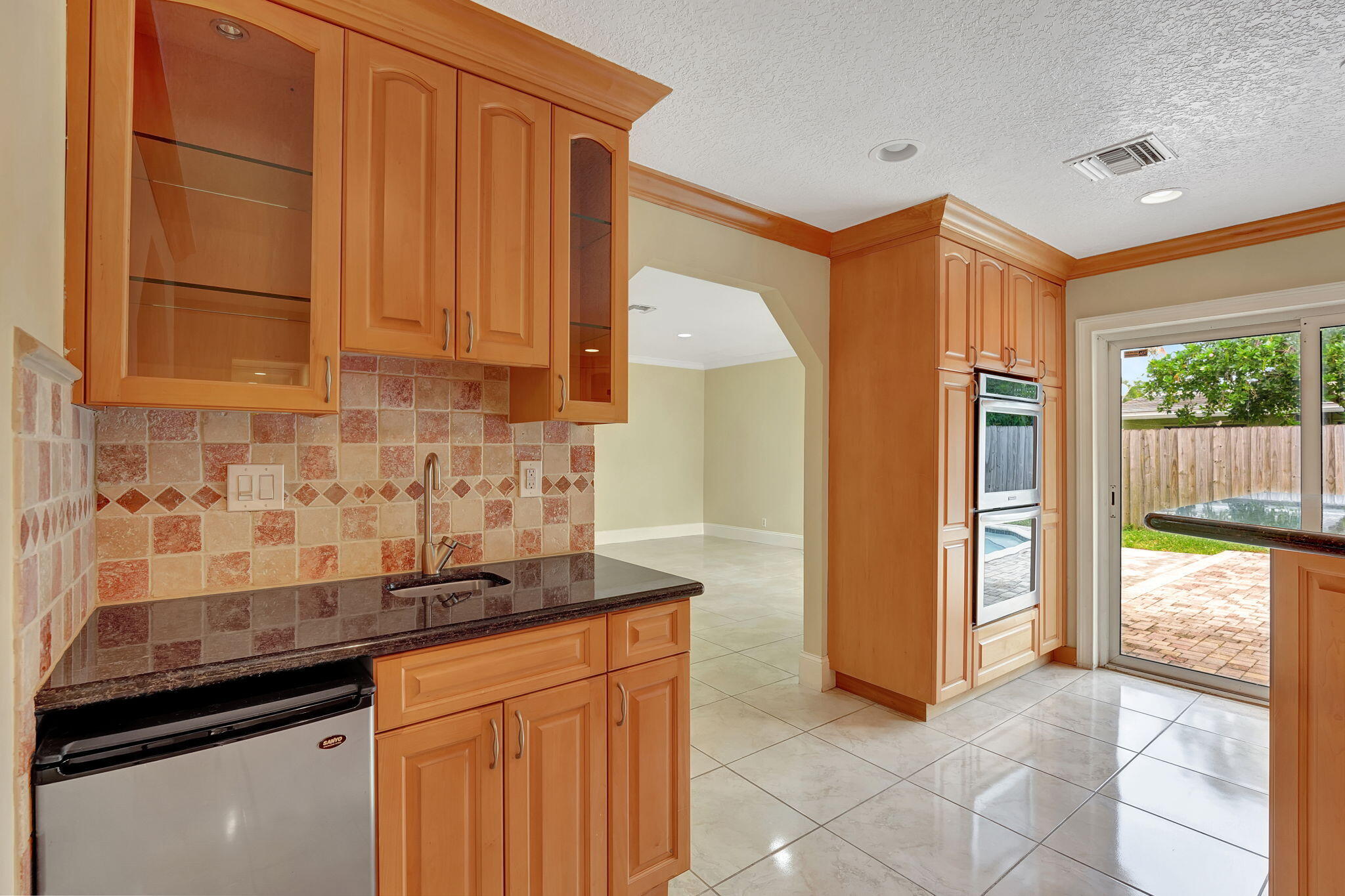 1300 Northeast 26th Avenue Pompano Beach, FL 33062 - Photo 56 of 68 a kitchen with granite countertop a sink and a refrigerator