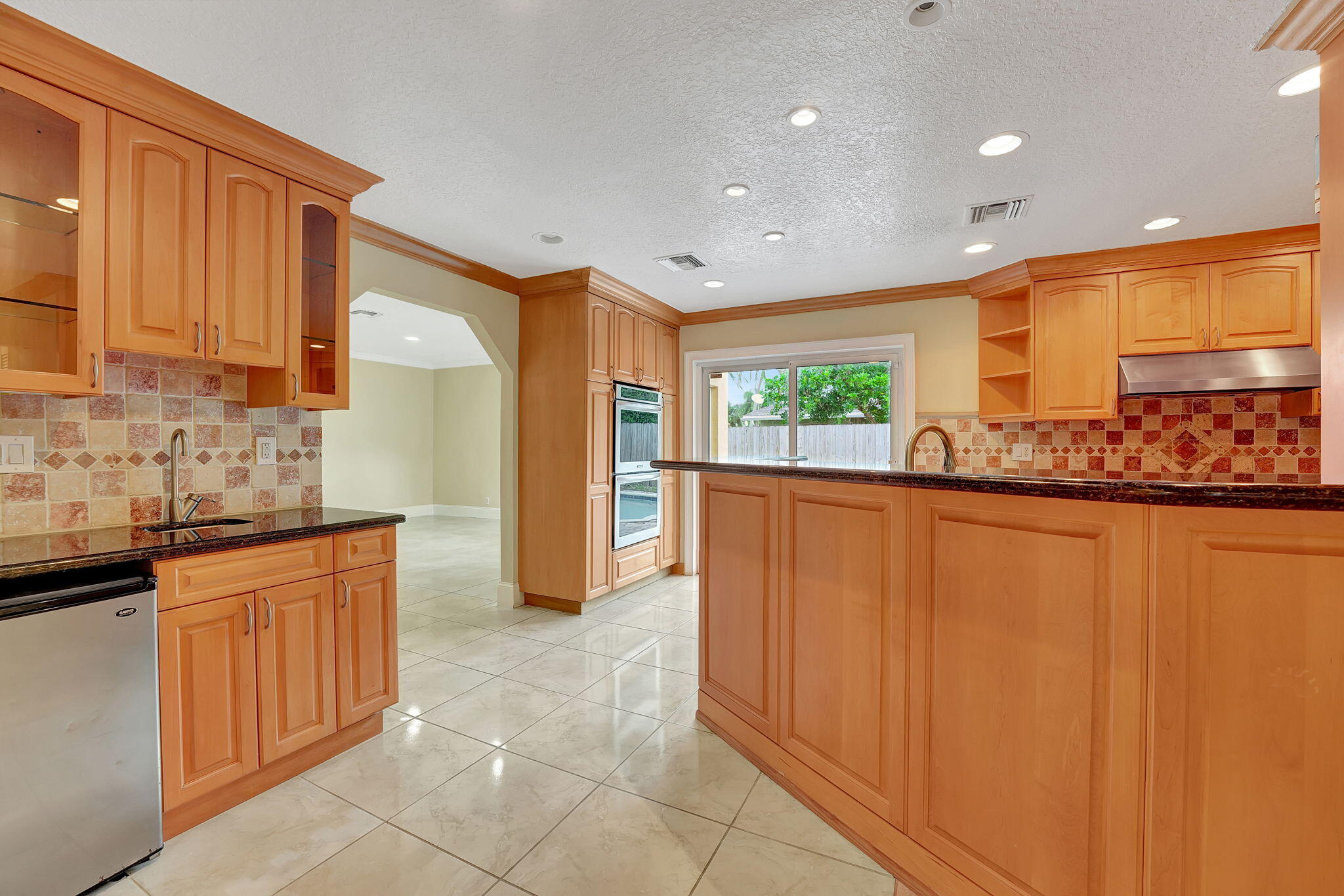 1300 Northeast 26th Avenue Pompano Beach, FL 33062 - Photo 64 of 68 a kitchen with stainless steel appliances granite countertop a refrigerator and a sink