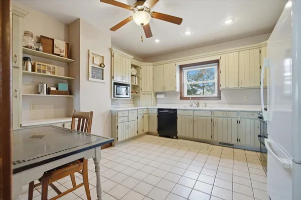 a kitchen with a stove a sink dishwasher a dining table and chairs