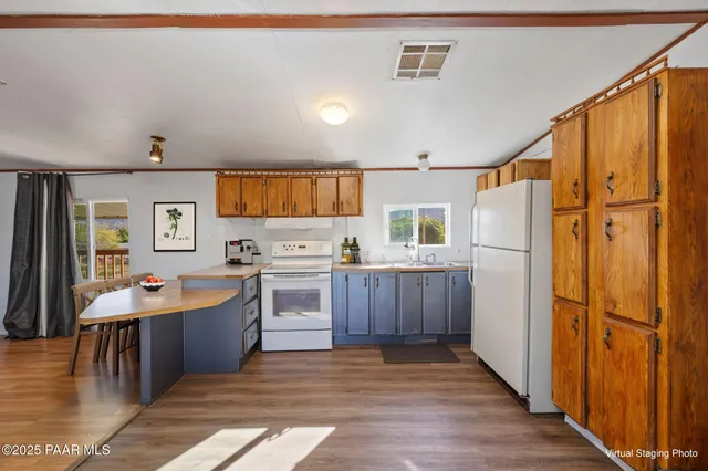a kitchen with cabinets a sink a window and stainless steel appliances