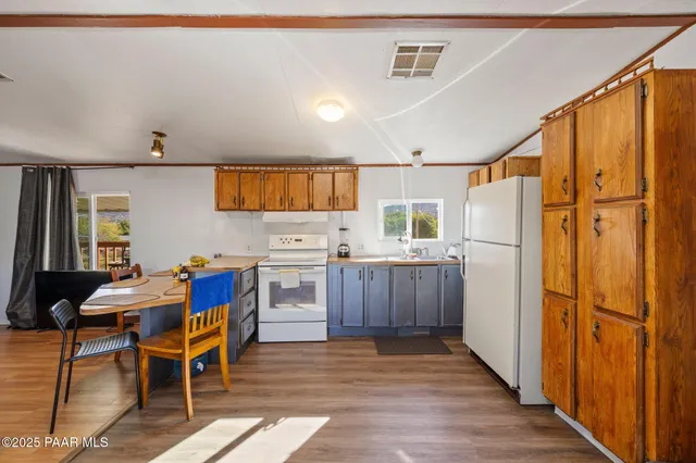 a kitchen with stainless steel appliances wooden floors and wooden cabinets