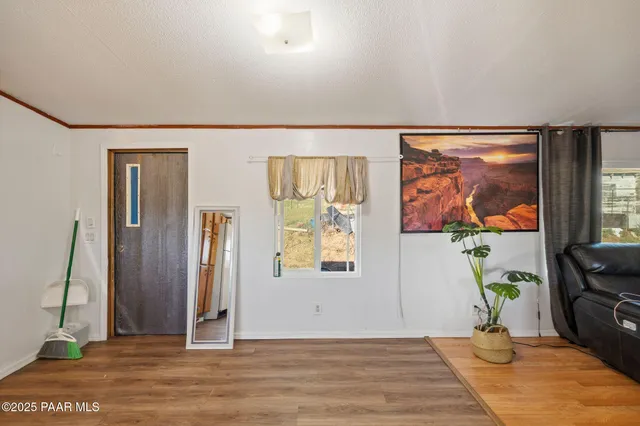 a view of a livingroom with wooden floor and a painting on the wall