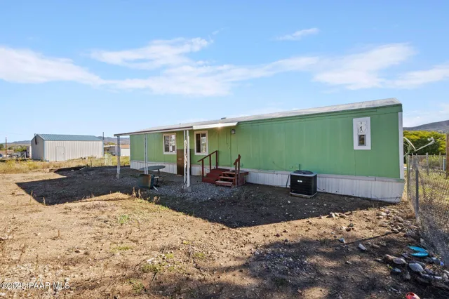 a view of a big house with a big yard and large trees