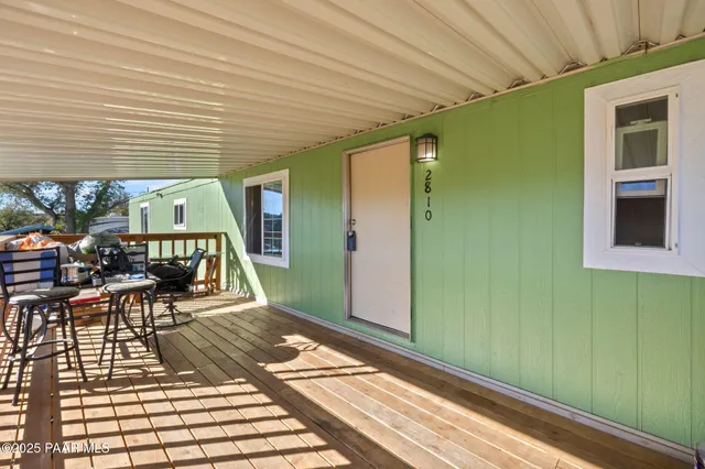 a view of a patio with table and chairs with wooden floor and fence