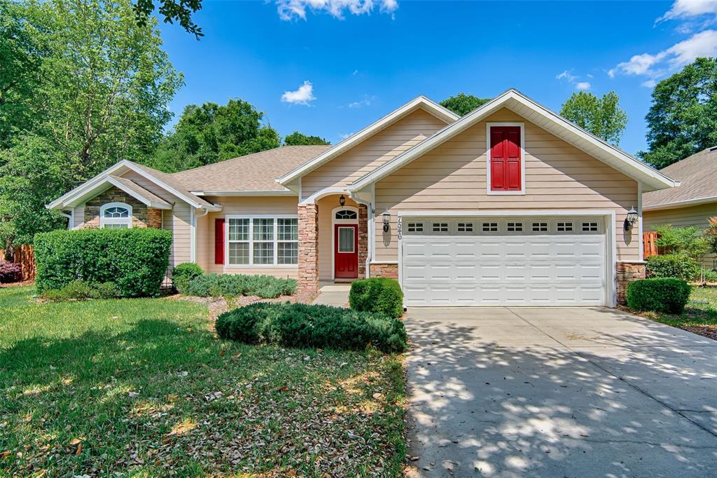 7546 Southwest 90th Drive Gainesville, FL 32608 - Photo 2 of 46 a front view of a house with a yard and garage