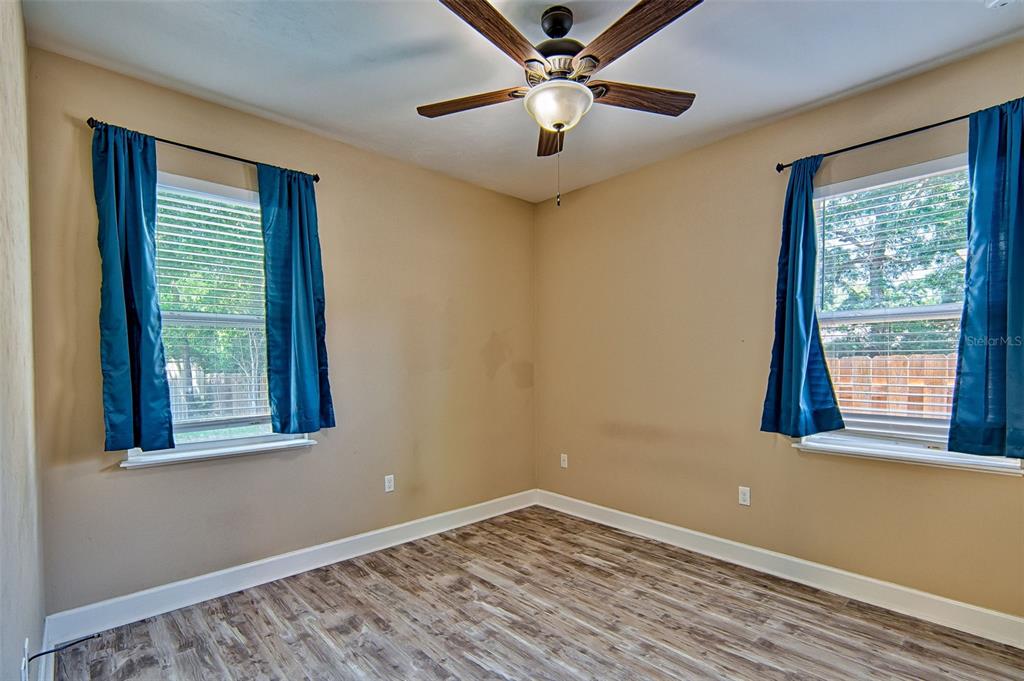 7546 Southwest 90th Drive Gainesville, FL 32608 - Photo 23 of 46 a view of empty room with wooden floor and fan