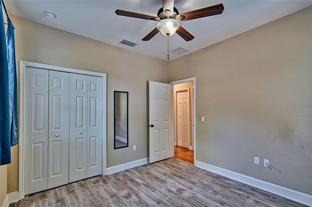 7546 Southwest 90th Drive Gainesville, FL 32608 - Photo 24 of 46 an empty room with wooden floor closet and ceiling fan