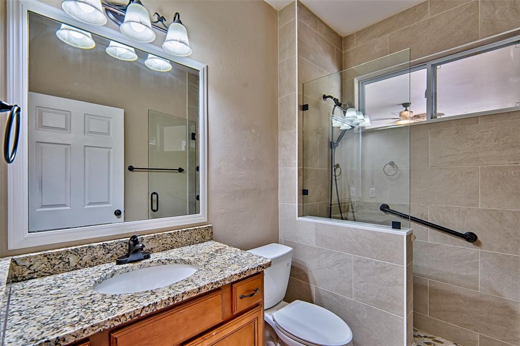 7546 Southwest 90th Drive Gainesville, FL 32608 - Photo 25 of 46 a bathroom with a granite countertop sink toilet and mirror