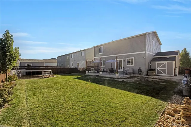 a view of a house with a big yard and large trees