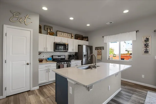 a kitchen with a sink a counter top space and stainless steel appliances