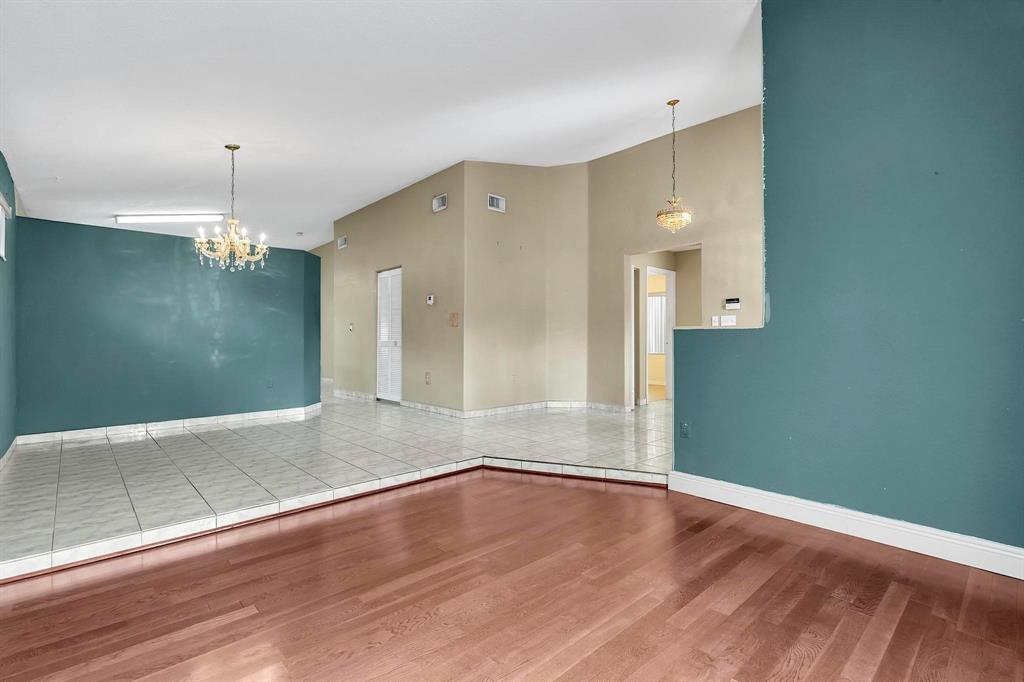 3201 West 76th Street Hialeah, FL 33018 - Photo 16 of 46 an empty room with wooden floor and chandelier