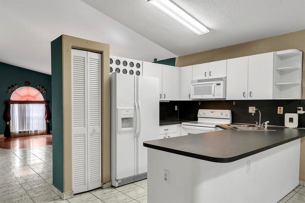 3201 West 76th Street Hialeah, FL 33018 - Photo 21 of 46 a kitchen with a refrigerator and a stove top oven