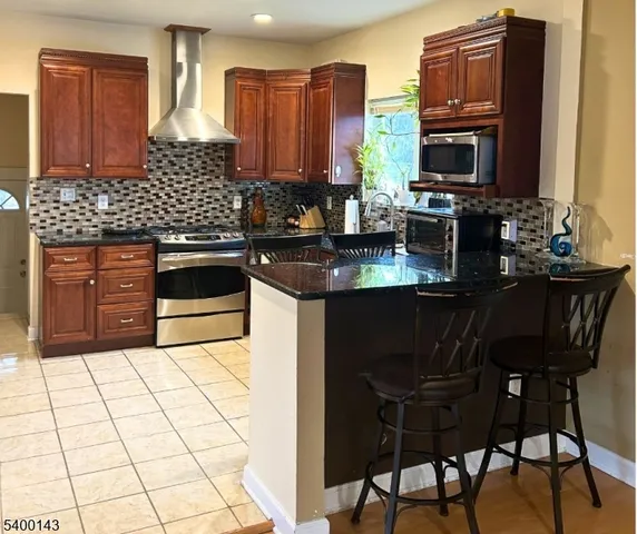 a kitchen with stainless steel appliances granite countertop a stove a sink a microwave and a refrigerator