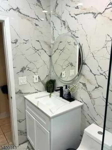 a bathroom with a sink and mirror with toilet