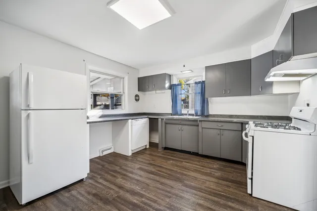 a kitchen with a refrigerator and a stove top oven