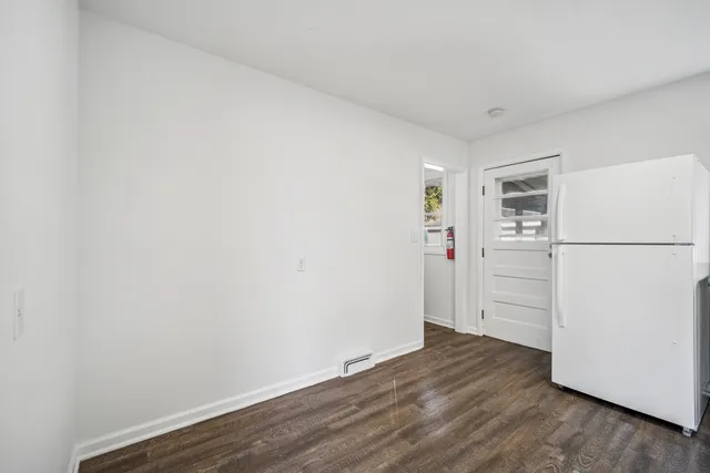 a view of a kitchen with wooden floor and refrigerator