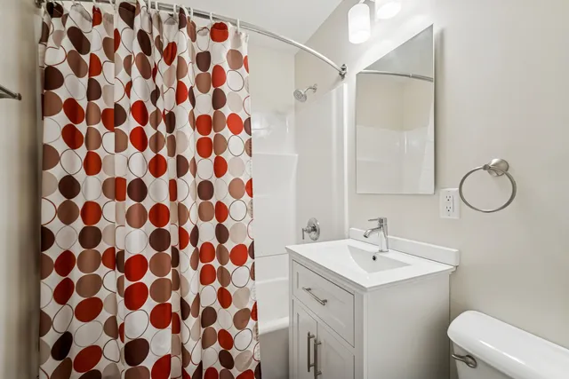 a bathroom with a sink and mirror with toilet