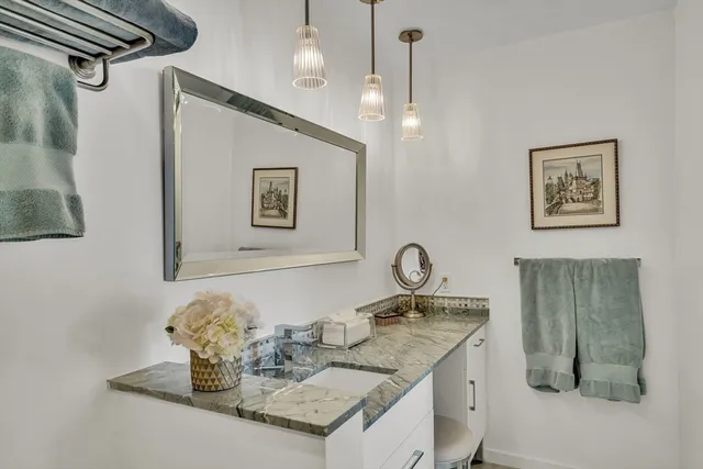 a bathroom with a granite countertop sink a mirror and vanity
