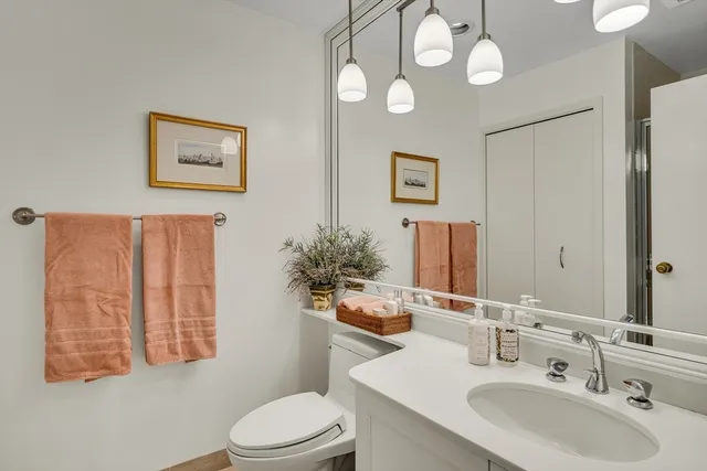 a bathroom with a sink vanity mirror and toilet