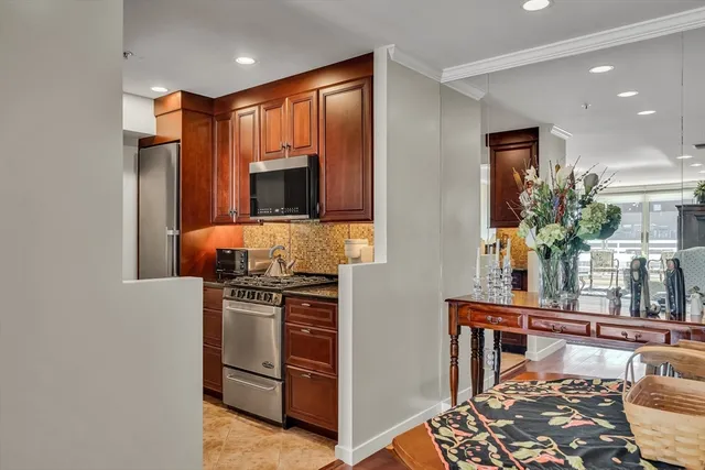 a kitchen with stainless steel appliances granite countertop a stove a sink and a microwave