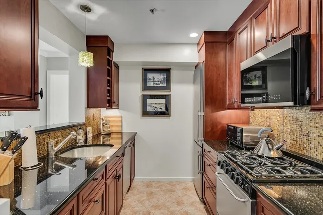a kitchen with stainless steel appliances granite countertop a sink stove and cabinets