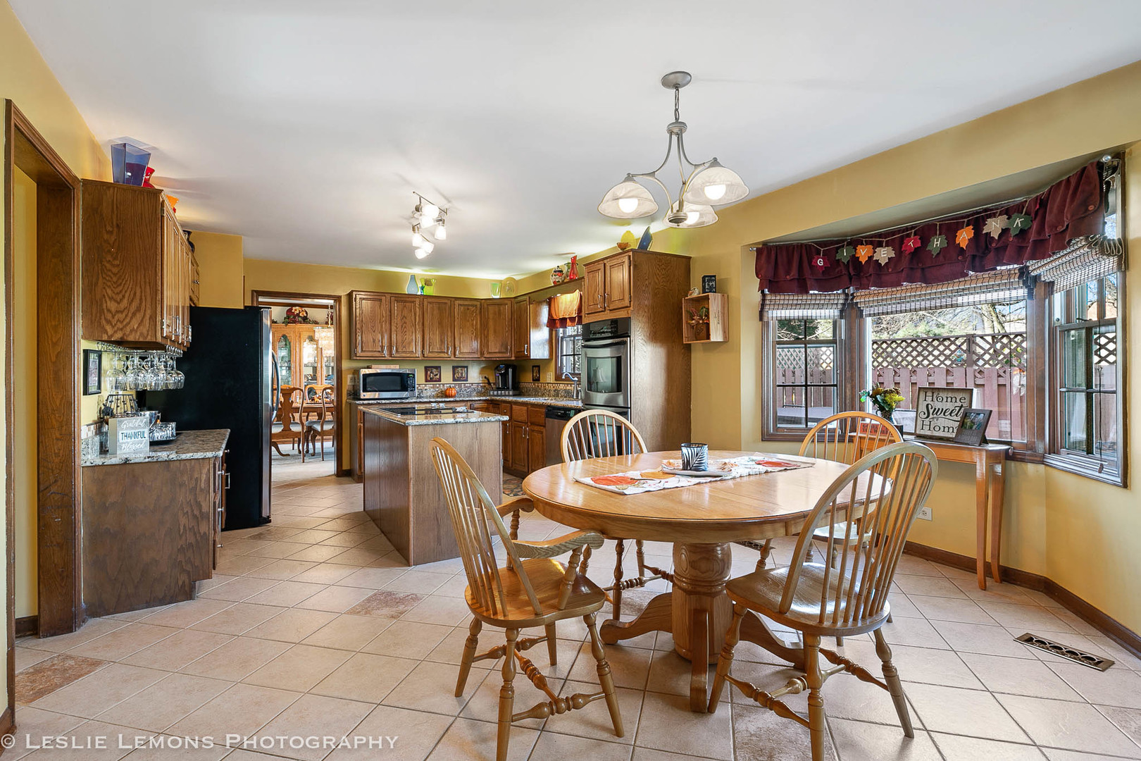 217 West Bailey Road Naperville, IL 60565 - Photo 2 of 24 a dining room with stainless steel appliances granite countertop a table chairs and a refrigerator