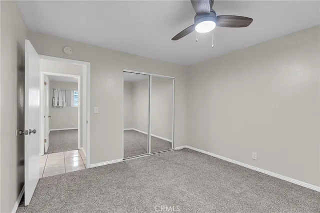 an empty room with fan and entrance