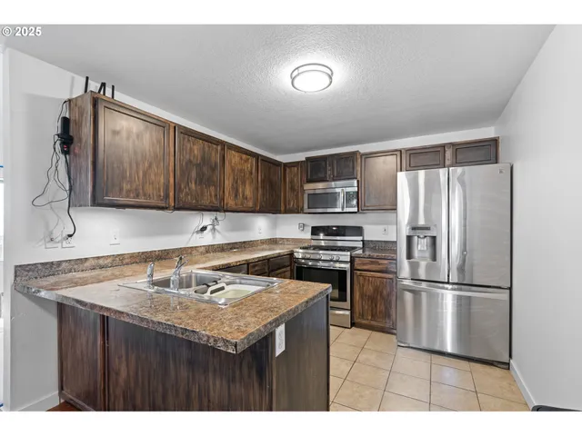 a kitchen with a refrigerator sink and cabinets