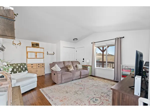 a living room with furniture a flat screen tv and a view of kitchen