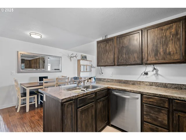 a kitchen with a sink a stove a microwave a counter top space and cabinets