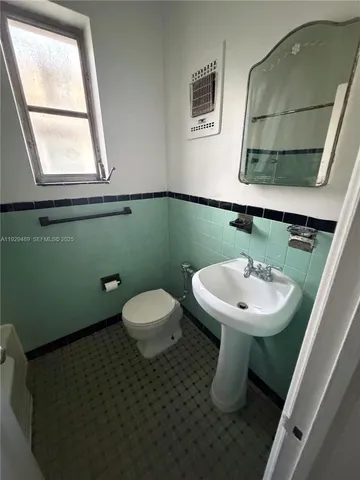 a bathroom with a sink toilet and mirror