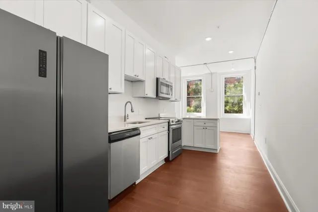 a view of kitchen with wooden floor and electronic appliances