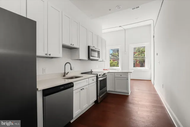 a kitchen with stainless steel appliances granite countertop a refrigerator and a sink