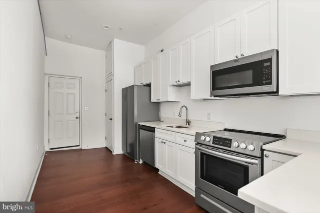 an empty room with wooden floor and white walls