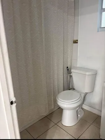 a white toilet sitting next to a white cabinet