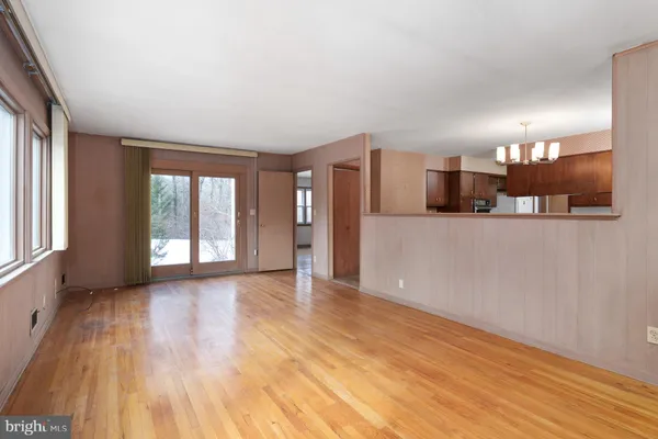 a view of a big room with wooden floor and windows