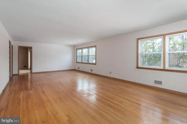 a view of a room with wooden floor and windows
